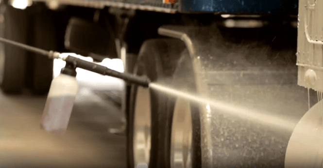 A trucker uses the Hotsy Foam Canon while washing his truck.