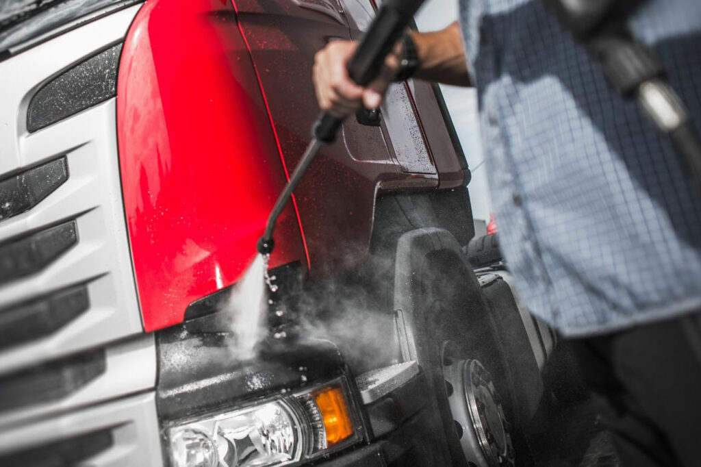 Washing a truck with a high-powered wash bay pressure washer