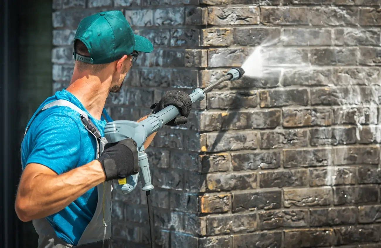 check-commercial-pressure-washer-pump man cleaning an outside wall with a pressure washer