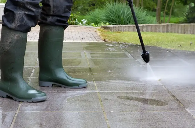 A man uses a pressure washer pump.