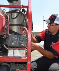 Technician installing a commercial pressure washer system outdoors