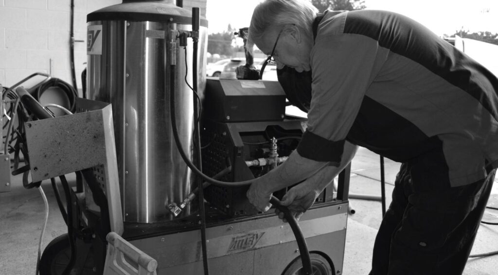 Technician servicing a commercial pressure washer system
